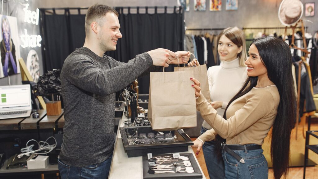 Hombre haciendo una venta a mujeres en tienda