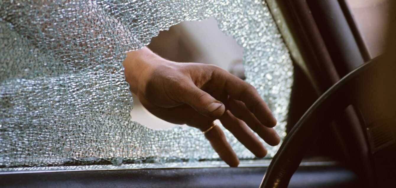 Hombre robando de un auto con ventana rota